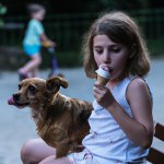 A girl eating ice-cream with a dog aside (1).jpg