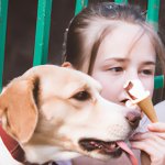 A girl eating ice-cream with a dog aside, eyes open (1).jpg